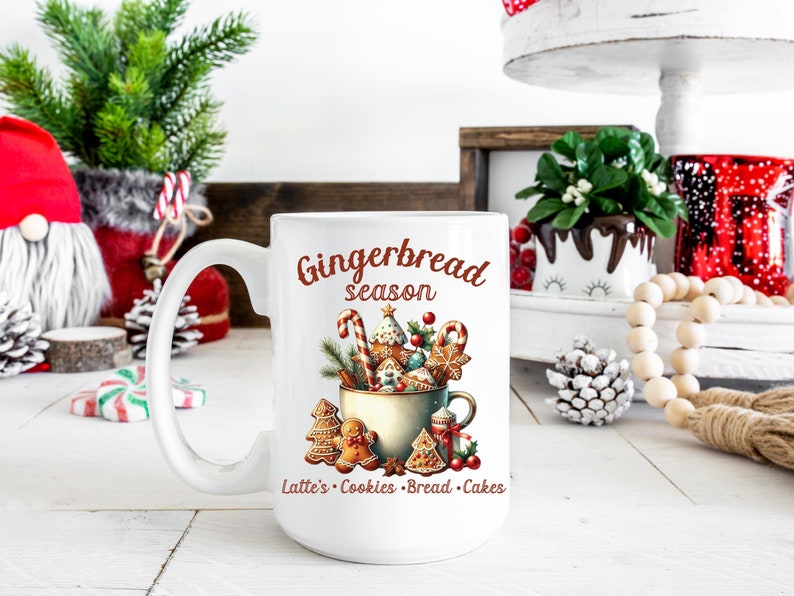 May include: White ceramic mug with a festive "Gingerbread season" design. The mug features a watercolor illustration of gingerbread cookies, candy canes, and greenery. Text at the bottom reads "Latte's Cookies Bread Cakes".