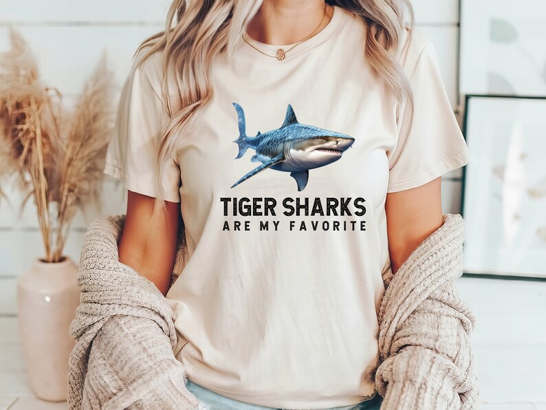 May include: A white t-shirt with a blue tiger shark graphic and the text "Tiger Sharks Are My Favorite".