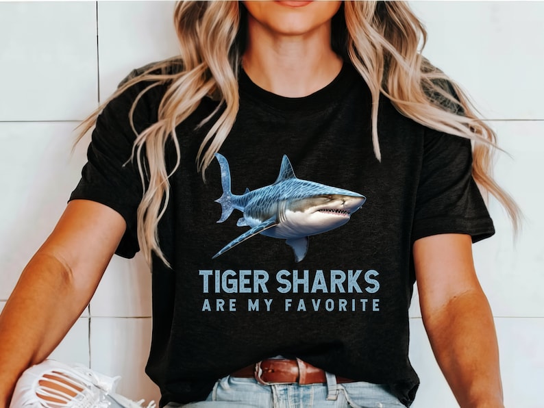 May include: A black t-shirt with a blue tiger shark graphic and the text "Tiger Sharks Are My Favorite".