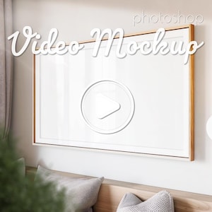 May include: A white framed video mockup with a play button icon in the centre. The frame is made of wood with a light brown finish. The text "Video Mockup" is written in white cursive letters above the frame.