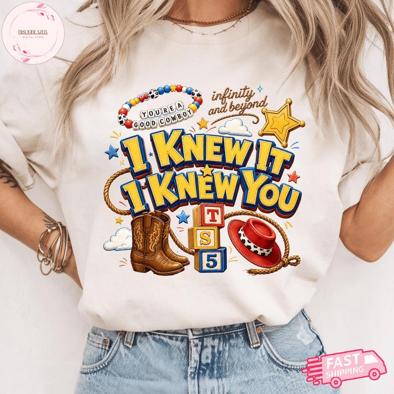 May include: A cream-colored t-shirt featuring a graphic print with the text "I KNEW IT I KNEW YOU" in blue and yellow, a beaded bracelet with "YOU'RE A GOOD COWBOY", a brown cowboy boot, a red hat, a lasso, alphabet blocks, and a gold star.