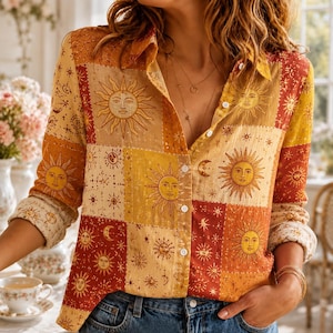 Può includere: Una camicia a maniche lunghe con bottoni caratterizzata da un motivo patchwork di soli, lune e stelle nei toni del giallo, arancione e rosso scuro. La camicia presenta un colletto classico, bottoni bianchi e maniche risvoltate, indossata con jeans blu.