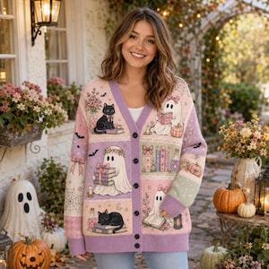 May include: A long-sleeve V-neck cardigan in pastel pink, purple, and green featuring a knit pattern of ghosts, black cats, books, pumpkins, spiderwebs, and bows. The button-down sweater has a ribbed trim along the neckline, cuffs, and hem.