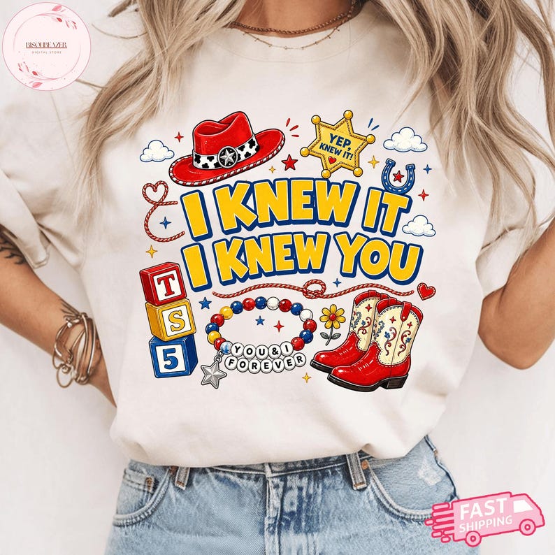 Pode incluir: Uma t-shirt cor de creme com uma estampa gr&aacute;fica de um chap&eacute;u de cowboy vermelho, uma estrela de xerife amarela com o texto YEP, KNEW IT!, blocos empilhados com T, S, 5, uma pulseira de contas com o texto YOU & I FOREVER e botas de cowboy vermelhas.