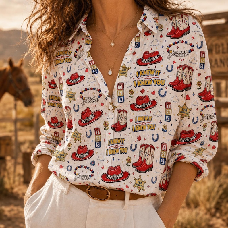 May include: A white long-sleeve button-down shirt featuring a repeating pattern of red cowboy hats, red cowboy boots, blue horseshoes, yellow sheriff stars, and the text I KNEW IT I KNEW YOU in blue and yellow lettering with a brown belt.