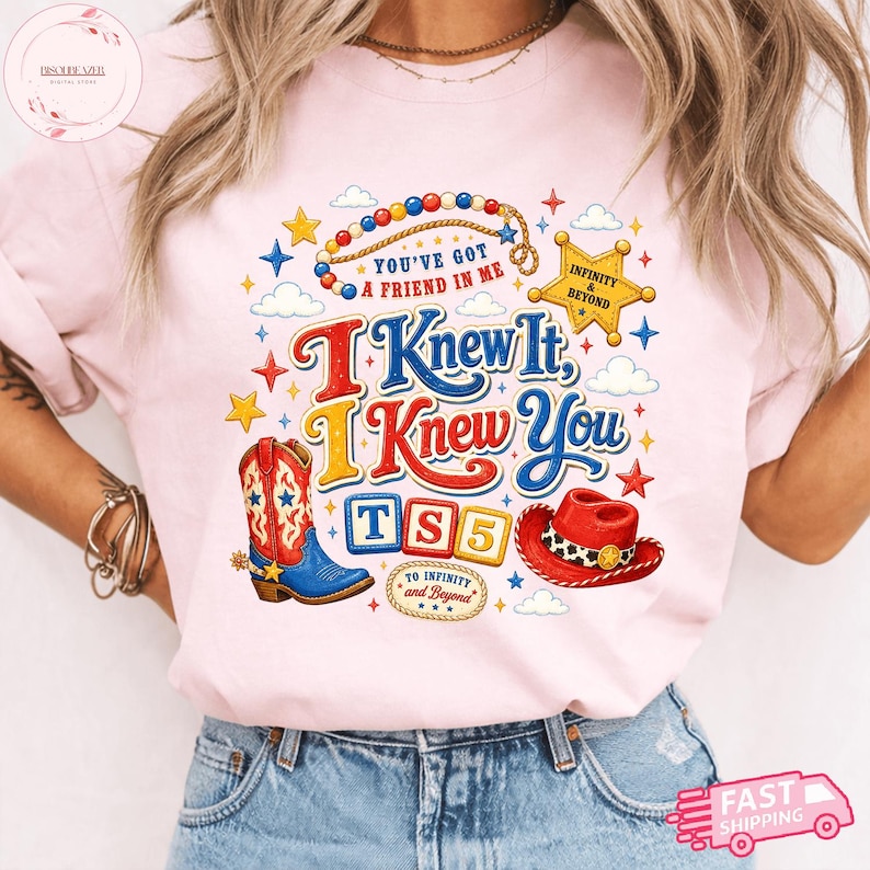 May include: A light pink t-shirt featuring a graphic print with the text "You've Got A Friend In Me", "I Knew It, I Knew You", "TS5", and "To Infinity and Beyond". The design includes a cowboy boot, a red hat, a star, clouds, and colorful beads.