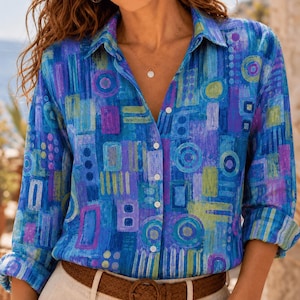 May include: A long-sleeved button-down shirt featuring a vibrant abstract pattern in shades of blue, purple, and lime green. The design consists of various geometric shapes, including circles and rectangles, with a collar and white buttons.
