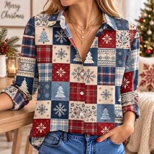 Pode incluir: Uma camisa de manga comprida com botões e um padrão de patchwork de quadrados vermelhos, azuis e creme. O design inclui motivos repetitivos de árvores de Natal, flocos de neve intrincados e texturas xadrez, com colarinho e botões brancos.