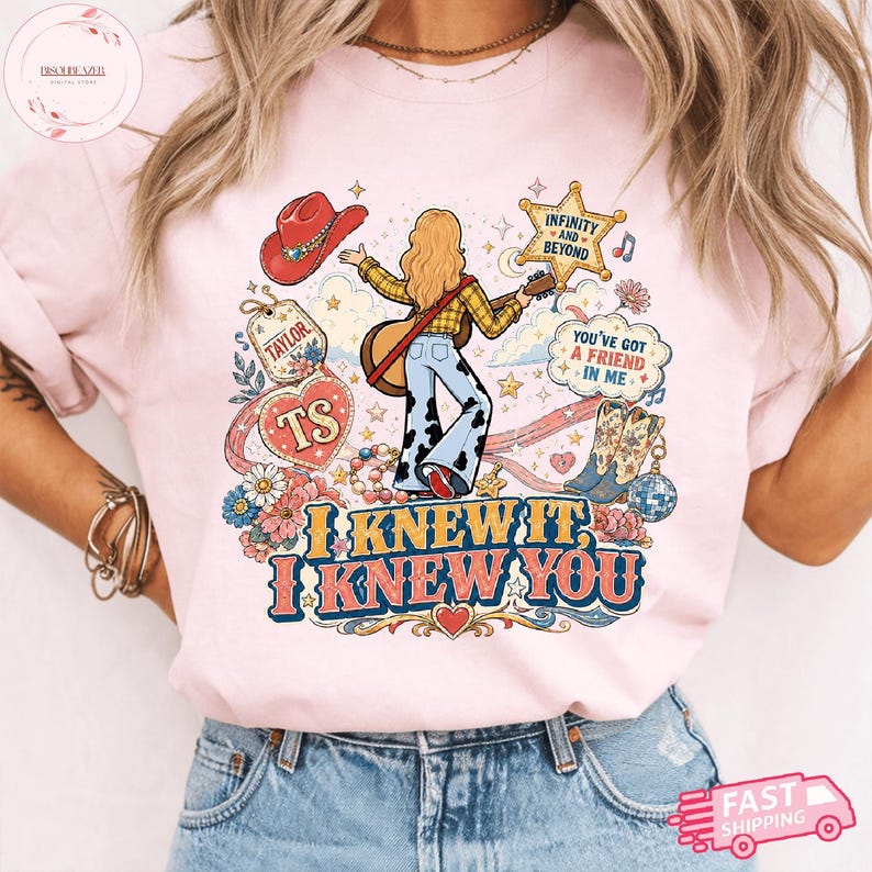 Może przedstawiać: Jasnor&oacute;żowy t-shirt z nadrukiem graficznym przedstawiającym osobę z długimi blond włosami grającą na gitarze, otoczoną czerwonym kowbojskim kapeluszem, gwiazdą, kwiatami, butami oraz tekstem "INFINITY AND BEYOND," "YOU'VE GOT A FRIEND IN ME," "TAYLOR," "TS," "I KNEW IT, I KNEW YOU."