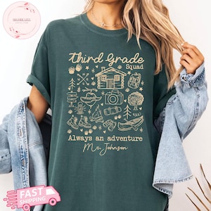 May include: Dark green t-shirt with the words "Third Grade Squad" and "Always an adventure Mr. Johnson" in a tan script. The shirt features camping-themed illustrations, including a cabin, backpack, and canoe.