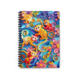 May include: A spiral bound notebook with a colorful design featuring monkeys and flowers made from paper. The monkeys are yellow, orange, and red, and the flowers are pink, yellow, and blue. The background is a light blue.