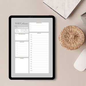 Könnte beinhalten: Ein graues digitales Tablet mit einer geöffneten Tagesplaner-App. Die App hat Bereiche für Datum, Stimmung, Wetter, ein Zitat des Tages, Prioritäten, To-Do-Liste und einen Zeitplan.