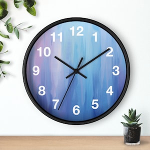 May include: A black framed clock with white numbers and hands on a blue and purple abstract background.