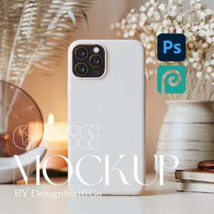 Puede incluir: Maqueta de funda de teléfono blanca con un recorte para cámara de triple lente. La funda se muestra verticalmente, con el texto "CASE MOCKUP" y "BY DesignSwiftCo" en primer plano. El fondo incluye flores, una vela e iconos de software de diseño.