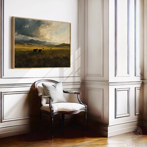 Puede incluir: Una pintura de paisaje enmarcada que representa un campo de hierba con un cielo dram&aacute;tico y monta&ntilde;as en la distancia. Tres figuras oscuras de ganado caminan a trav&eacute;s del campo.