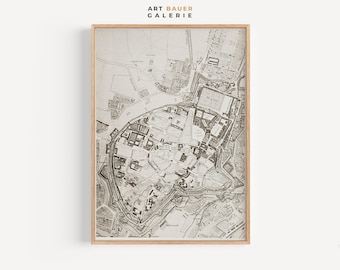 May include: A vintage black and white map of a city, framed in a light wood frame. The map shows the layout of the city with streets, buildings, and other features. The title "ART BAUER GALERIE" is printed at the top of the frame.