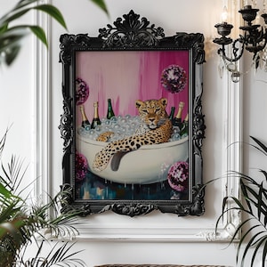 Könnte beinhalten: Gerahmtes Gemälde, das einen Leoparden in einem Schaumbad mit Champagnerflaschen zeigt. Das Kunstwerk hat einen schwarzen, verzierten Rahmen, einen rosa-weißen Hintergrund und dekorative Kugeln.