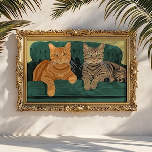 Op de afbeelding: Een ingelijste kunstdruk met twee katten op een groene fluwelen bank. Eén kat is oranje tabby, de andere is grijs tabby. De sierlijke gouden lijst voegt een vleugje elegantie toe aan dit kunstwerk met katten als thema.