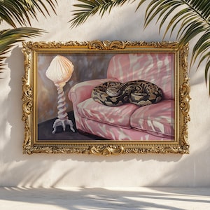 May include: A framed painting featuring a coiled snake resting on a pink sofa with a zebra stripe pattern. A white lamp with a seashell-shaped shade stands to the left. The ornate gold frame adds a touch of elegance to the artwork.
