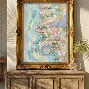 May include: A white ceramic mug with a black handle and the text "But First, Coffee" in a bold, black font. The mug is set against a blurred background, highlighting its simple design.