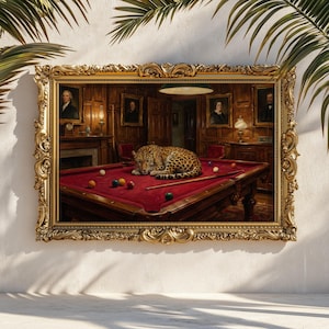 May include: A framed print featuring a leopard resting on a red pool table in a wood-paneled room. The ornate gold frame surrounds the image, which includes billiard balls, a cue stick, and portraits on the walls.