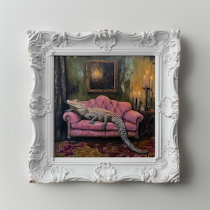 May include: A framed painting depicts an alligator lounging on a pink sofa. The artwork is set in a room with a dark, ornate aesthetic, featuring a small painting and a candelabra. The frame is white with intricate detailing.