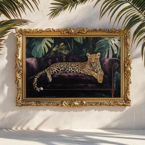 May include: A framed artwork featuring a leopard resting on a purple velvet sofa. The background depicts lush green foliage. The ornate gold frame adds a touch of elegance to the animal portrait.