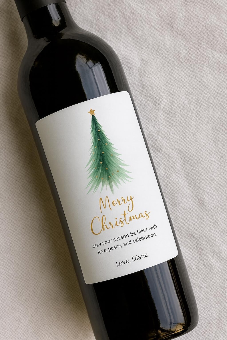 May include: A dark wine bottle with a white label featuring a watercolor Christmas tree design. The label includes the text "Merry Christmas" in gold script, along with a holiday message and a name.
