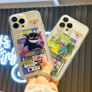 Może przedstawiać: Dwa przezroczyste etui na telefon z kolorowymi wzorami postaci Pokemon. Etui po lewej stronie przedstawia fioletową i czarną postać Genga z tekstem "WAR G" i "Pokemon". Etui po prawej stronie przedstawia zieloną postać Bulbasaura z tekstem "WAR G" i "Pokemon".