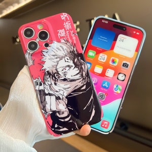 K&ouml;nnte beinhalten: Eine rosa iPhone-H&uuml;lle mit einer Schwarzwei&szlig;-Illustration eines Charakters aus dem Anime Jujutsu Kaisen. Die H&uuml;lle hat japanischen Text auf der R&uuml;ckseite. Die Handyh&uuml;lle wird neben einer durchsichtigen iPhone-H&uuml;lle mit blauem Rand gezeigt.