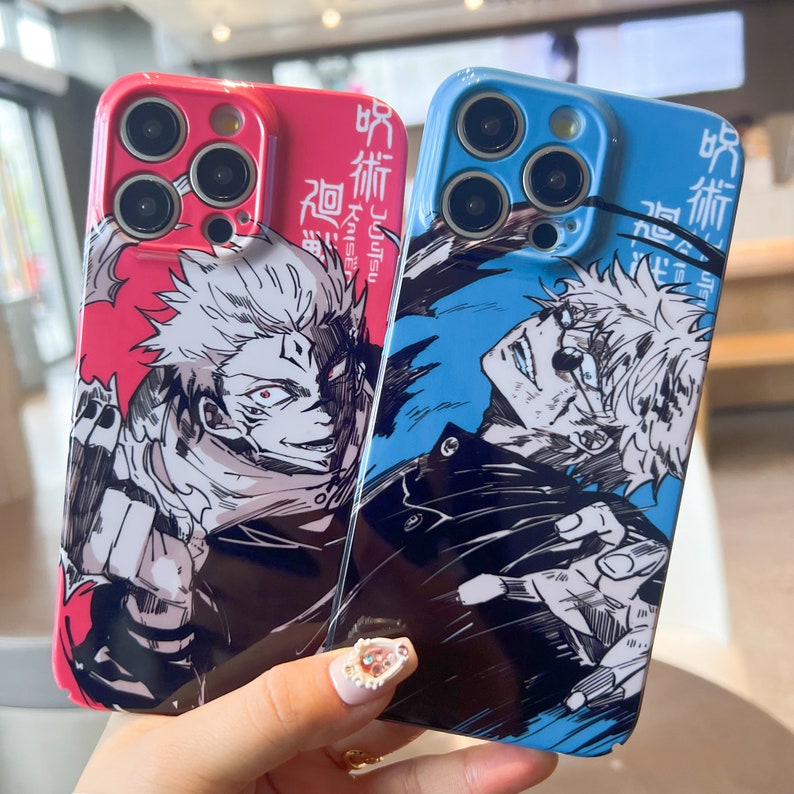 K&ouml;nnte beinhalten: Zwei Handyh&uuml;llen mit Anime-Charakteren. Die H&uuml;lle links ist pink mit einem wei&szlig;en Charakter mit schwarzen Haaren und einer schwarzen Jacke. Die H&uuml;lle rechts ist blau mit einem wei&szlig;en Charakter mit schwarzen Haaren und einer schwarzen Jacke. Beide H&uuml;llen haben japanischen Text.