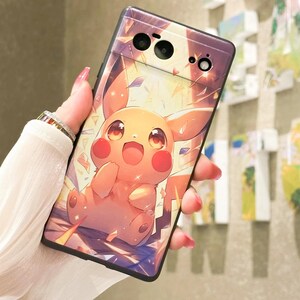 May include: A black phone case with a cartoon image of Pikachu, a yellow electric mouse Pokemon, with a bright yellow background and sparkling effects.