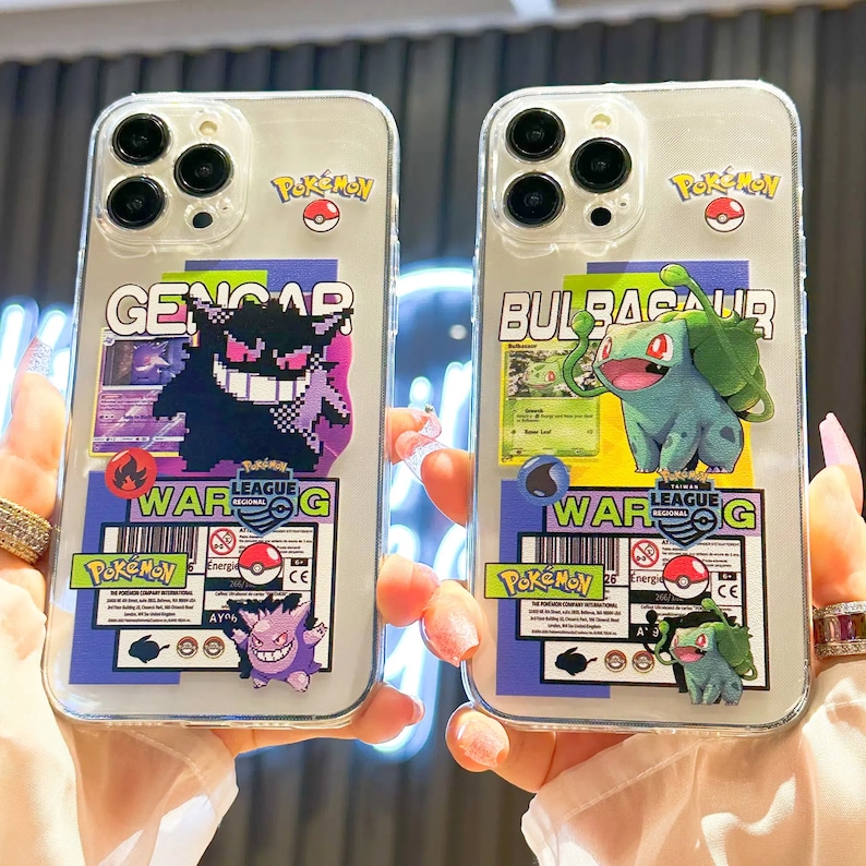 Może przedstawiać: Dwa przezroczyste etui na telefon z kolorowymi wzorami Pokemon&oacute;w. Lewa obudowa przedstawia czarno-fioletowego Pokemona Genogar z tekstem "WAR G" i "POKEMON". Prawa obudowa przedstawia zielonego Pokemona Bulbasaur z tekstem "WAR G" i "PokeMoY".