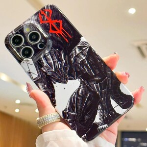 Może przedstawiać: Czarno-białe etui na telefon z grafiką postaci z anime Berserk. Postać jest ubrana w zbroję i trzyma miecz. Etui ma czerwony napis "Berserk" u g&oacute;ry.