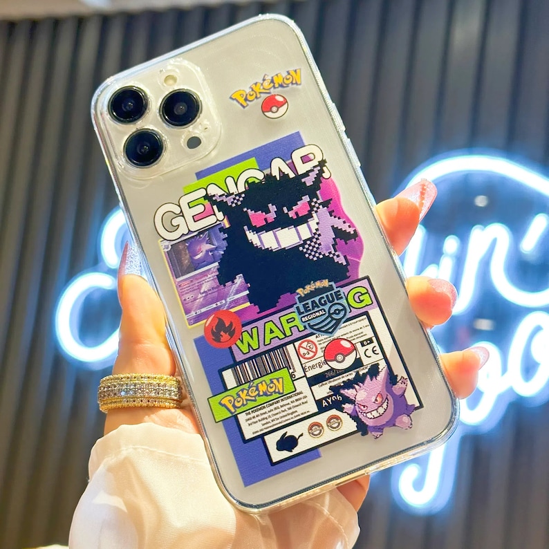 Może przedstawiać: Przezroczyste etui na telefon z kolorowym wzorem Pokemon. Etui przedstawia postać Pokemon Genga, logo Pokemon League i tekst "WAR G".