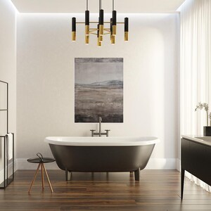 K&ouml;nnte beinhalten: Ein modernes Badezimmer mit einer freistehenden Badewanne in Dunkelgrau, einem schwarzen Waschtisch und einem schwarz-goldenen Kronleuchter. Ein Landschaftsbild h&auml;ngt &uuml;ber der Wanne. Der Raum hat Holzb&ouml;den.