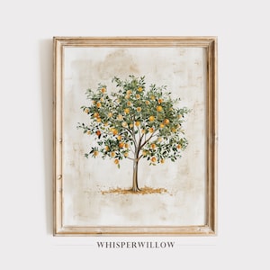 Op de afbeelding: Een ingelijst aquarel schilderij van een sinaasappelboom met groene bladeren en oranje vruchten. De achtergrond is licht beige met een subtiele textuur. De lijst is van licht hout.