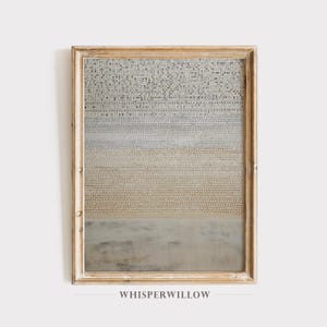 May include: Framed abstract art print with a textured, layered design in shades of gray, beige, and white. The artwork is encased in a light brown wooden frame. The text "WHISPERWILLOW" is printed at the bottom.