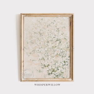 May include: A framed wall art print featuring an impressionistic painting of a dense cluster of white flowers with soft green foliage accents against a neutral beige background. The artwork is encased in a light-toned wooden frame with a visible grain.