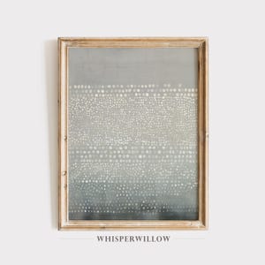 May include: Abstract art print in a distressed, light-toned wooden frame. The artwork features a gradient of gray hues with a pattern of white dots. The text "WHISPERWILLOW" is printed at the bottom of the frame.