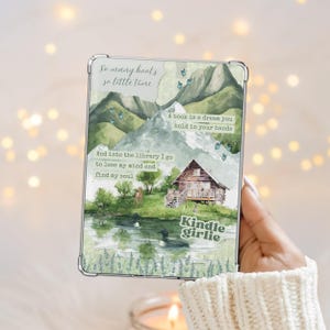 Könnte beinhalten: Eine Kindle-Hülle mit einem Aquarelldesign mit Bergen, einem See und einer Hütte. Die Hülle hat den Text "So many books, so little time", "A book is a dream you hold in your hands" und "Kindle girlie."