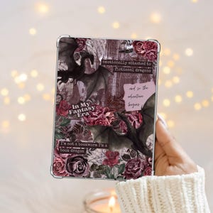 May include: A clear tablet case featuring a dark collage design with black dragons, deep red roses, and vintage paper textures. Text includes: "emotionally attached to fictional dragons," "In My Fantasy Era," "and so the adventure begins," and "I'm not a bookworm I'm a book dragon."