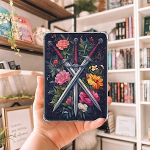 Könnte beinhalten: Eine Handyhülle mit einem Design aus drei gekreuzten Schwertern, umgeben von Blumen in Rosa-, Gelb- und Weißtönen. Der Hintergrund ist dunkelblau mit einem Sternenmuster.