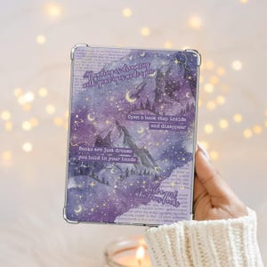 May include: A rectangular case with a purple and white mountain and starry night design. The case has text that reads "Reading is dreaming with your eyes wide open", "Open a book step inside and disappear", "Books are just dreams you hold in your hands", and "Just a girl who loves books".