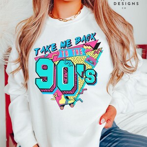 Puede incluir: Sudadera blanca con un estampado gr&aacute;fico del texto "Take Me Back to the 90's" en un estilo retro colorido. El gr&aacute;fico incluye un pat&iacute;n, una cinta de casete y formas geom&eacute;tricas.