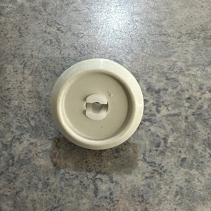 May include: A white plastic knob with a small white plastic clip in the center.