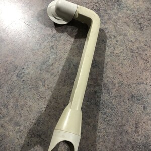 May include: A white plastic shower head holder with a curved arm and a suction cup base.