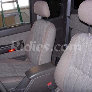 May include: Two gray fabric car seats with headrests in a vehicle interior. The seats have a patterned fabric and are in good condition.