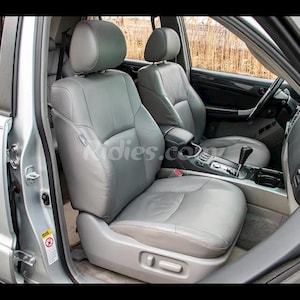 Pode incluir: O interior de um SUV prateado com dois bancos de couro cinza. O banco do motorista está em primeiro plano e tem um botão de ajuste elétrico. O banco do passageiro está no fundo.