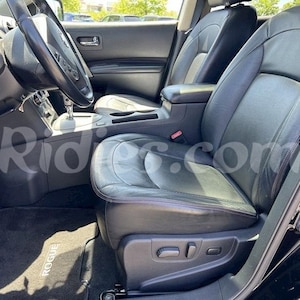 Puede incluir: Interior de cuero negro de un coche con un asiento del conductor y un asiento del pasajero. El asiento del conductor tiene controles eléctricos y la alfombra del piso dice "Rogue".